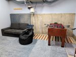 Hangout area in garage with fuseball and couch. Also have TV in this space. 